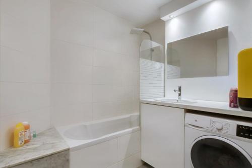 une salle de bain blanche avec une machine à laver et un lavabo dans l'établissement La Comtesse du Barry - Appt 2p avec terrasse, à Toulouse