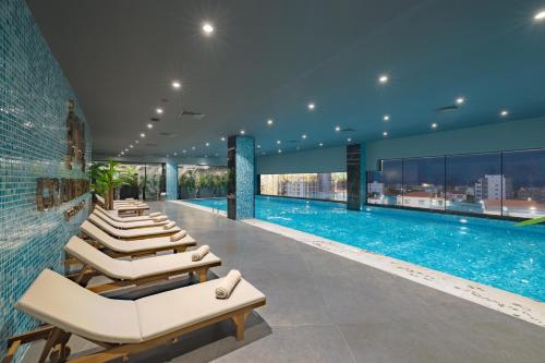 a swimming pool with lounge chairs in a building at Grand Sapphire Residence By Aircyp in Iskele