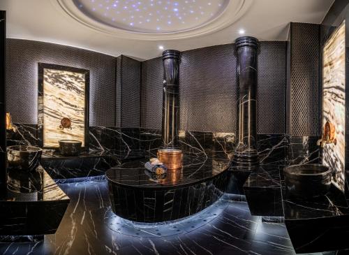 a bathroom with black marble and a round tub at Grand Sapphire Residence By Aircyp in Iskele