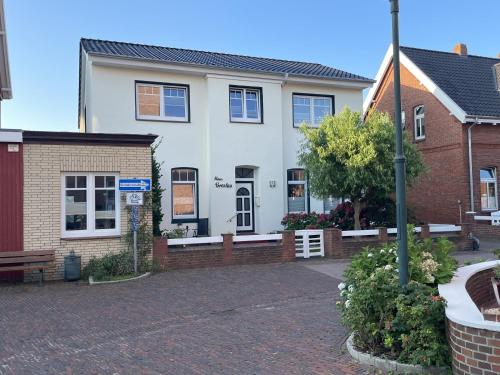 a white house with a brick driveway at Haus Breslau in Borkum