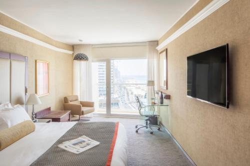 a hotel room with a bed and a flat screen tv at Renaissance Tel Aviv Hotel in Tel Aviv