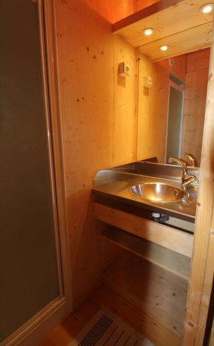 une salle de bain avec un lavabo et un miroir dans l'établissement Cabane Perchée Jurassic Piscine, Spa et Hammam proche des Gorges de l'Aveyron, à Lavaurette