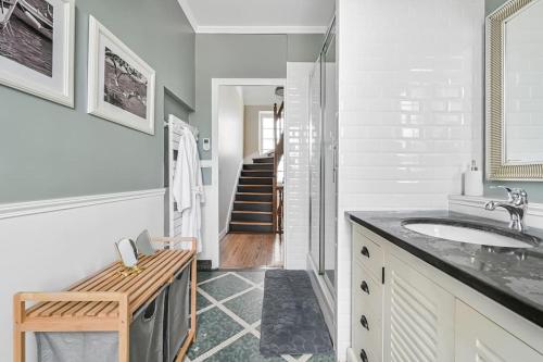 La salle de bains blanche est pourvue d'un lavabo et d'un escalier. dans l'établissement Villa Harmonia - 10p - Cinéma - Piscine - Billard, à Vaires-sur-Marne