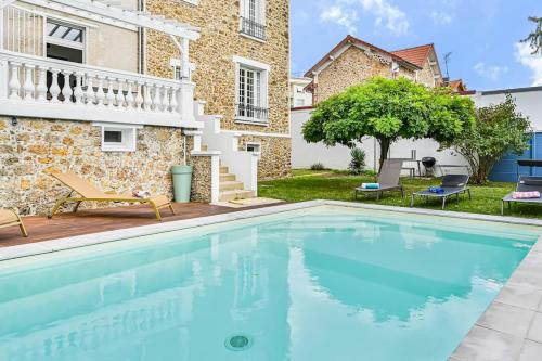 une piscine devant une maison dans l'établissement Villa Harmonia - 10p - Cinéma - Piscine - Billard, à Vaires-sur-Marne