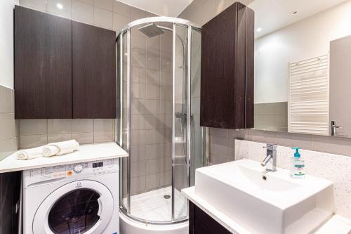 une salle de bain avec une machine à laver et un lavabo dans l'établissement GuestReady - Séjour Cosy Familial pour 4, à Paris