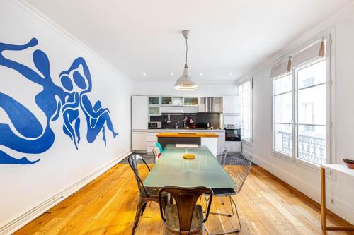 une cuisine avec une table et des chaises dans une pièce dans l'établissement GuestReady - Séjour Cosy Familial pour 4, à Paris