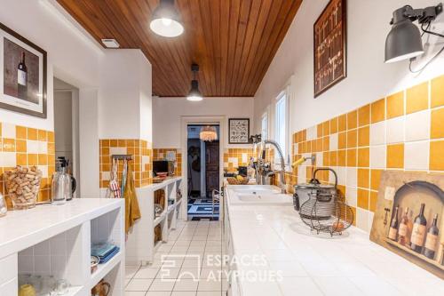 - une grande cuisine avec du carrelage jaune et blanc sur les murs dans l'établissement Villa de vacances avec vue mer et accès à la plage, à Vaux-sur-Mer