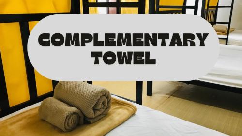 een bord met de tekst 'bankroettoren' met handdoeken op een tafel bij Silom Guesthouse in Bangkok