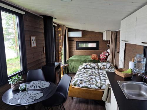 a room with a bedroom and a bed and a sink at Arctic Circle Beach House in Meltosjärvi