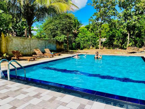 two people swimming in a swimming pool at Udawalawa Safari House in Udawalawe