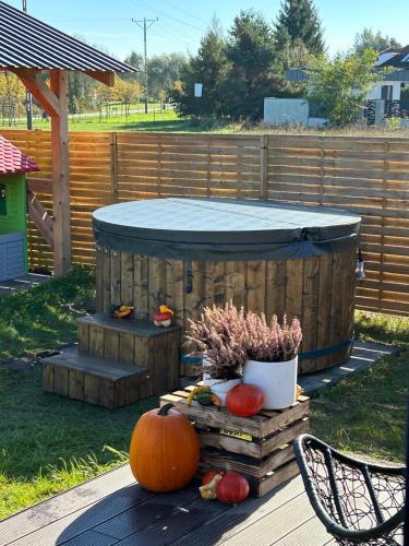 a pumpkin and pumpkins on a deck with a hot tub at Dwa Wymiary - Całoroczny domek z Jacuzzi i basenem podgrzewany w okresie wiosna - lato w cenie in Morawica