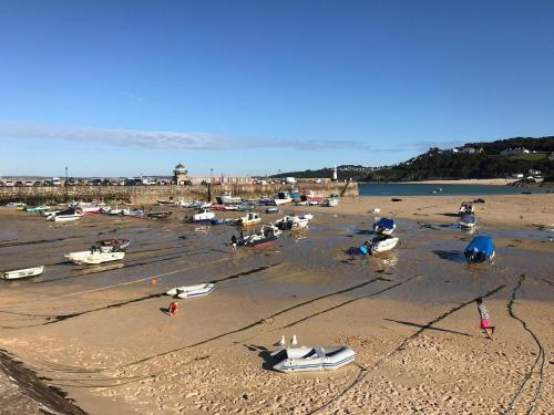 a group of boats on the sand on a beach at Morning Cottage in St Ives