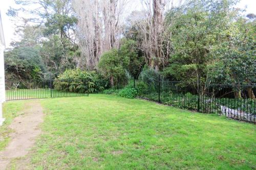 a large yard with a fence and trees at The Homestead in Cable Bay