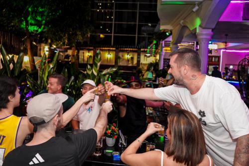 a man giving a drink to a group of people at Bliss & Beats Hostel in Phnom Penh