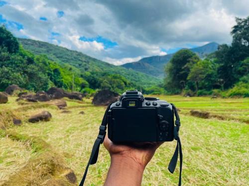 a person holding a camera in a field at Meemure Rawana Adawiya in Meemure