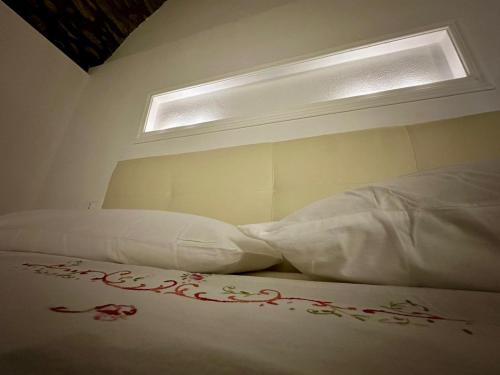 a bed with white sheets and a window in a room at La casa nel borgo in Terrarossa