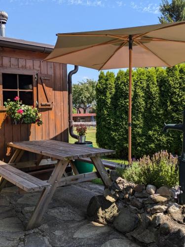 a wooden picnic table with an umbrella in a yard at Apartments Pihapperhof in Mittersill