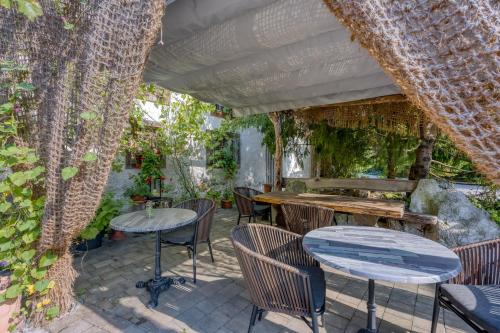 an outdoor patio with tables and chairs and vines at Luxury Glamping House Pia - Happy Rentals in Ivančna Gorica