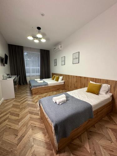 a bedroom with two beds and a desk in it at Mastersclub in Ternopilʼ
