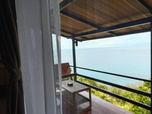 a room with a view of the ocean from a balcony at Nangyuan Island Dive Resort in Koh Tao