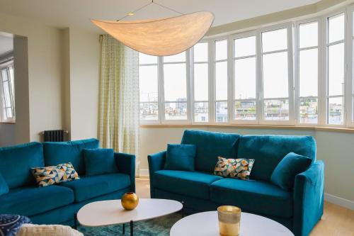 - un salon avec deux canapés bleus et deux tables dans l'établissement Appartement Spacieux pour 6 - Passy, Paris, à Paris