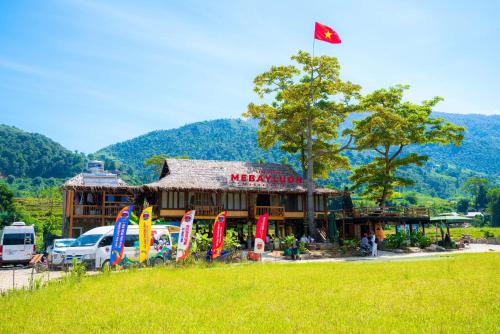 a building with a flag and flags in front of it at Clubhouse Mebayluon Paragliding--Homestay, Bay dù lượn, Bể bơi, Sân cỏ, Cắm trại in Pu Chu Chay