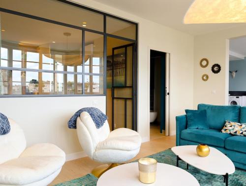 - un salon avec un canapé bleu et des fauteuils blancs dans l'établissement Appartement Spacieux pour 6 - Passy, Paris, à Paris