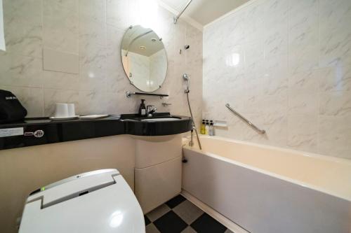 a bathroom with a sink and a toilet and a tub at KOKO HOTEL Osaka Shinsaibashi in Osaka