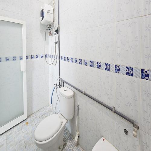 a bathroom with a white toilet in a room at Ijen Homestay Mojokerto RedPartner in Mojokerto