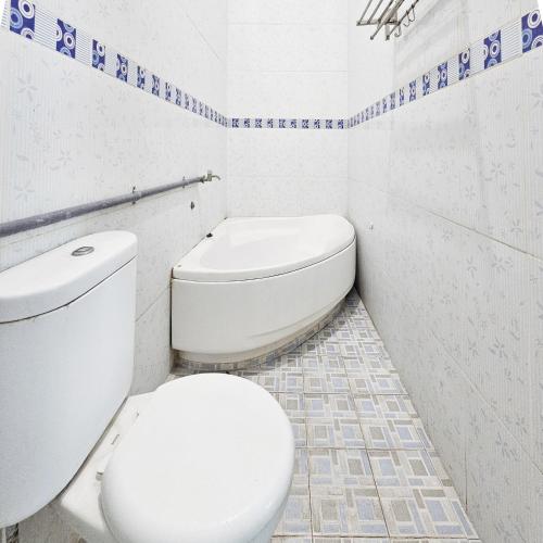 a white bathroom with a toilet and a sink at Ijen Homestay Mojokerto RedPartner in Mojokerto