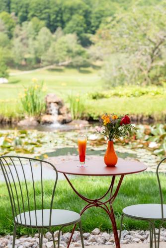 a table with a glass of orange juice and flowers on it at Le Domaine de Falgos Golf & Spa in Saint-Laurent-de-Cerdans