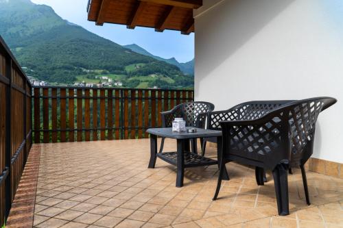two chairs and a table on a balcony with mountains at appartamento Van gogh in Oltre il Colle
