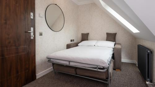 a bedroom with a bed with a mirror on the wall at Westlands of Pitlochry in Pitlochry