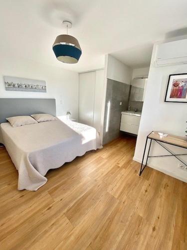 une chambre avec un lit et un parquet dans l'établissement Maison, jardinet, terrasse, parking privée, climatisation, à Saintes-Maries-de-la-Mer