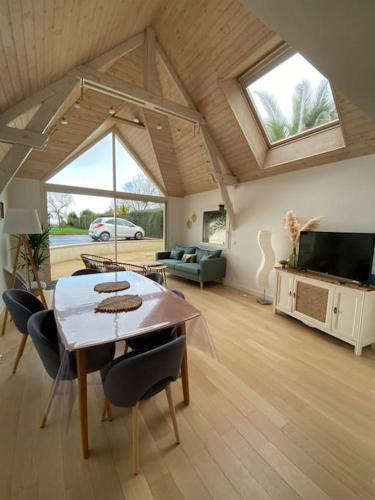 un salon avec une table et une télévision dans l'établissement L escapade, à Grandcamp-Maisy