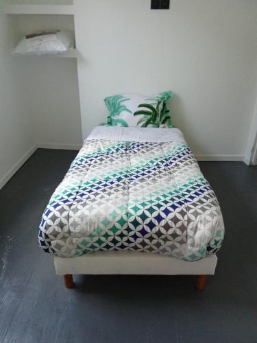 - un lit avec une couette dans l'établissement Le bloo, à Rouen