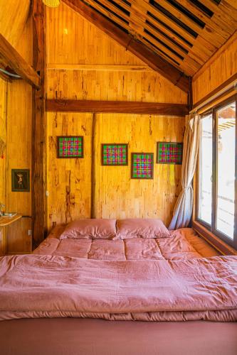 a large bed in a wooden room with windows at Clubhouse Mebayluon Paragliding--Homestay, Bay dù lượn, Bể bơi, Sân cỏ, Cắm trại in Pu Chu Chay