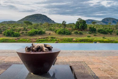 a bowl of rocks sitting on a table near a body of water at Royal Mukumbura Malelane in Malelane