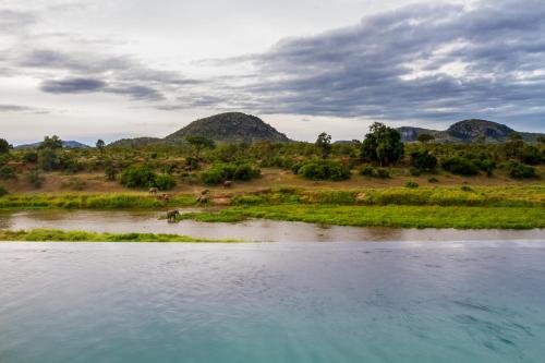 a body of water with mountains in the background at Royal Mukumbura Malelane in Malelane