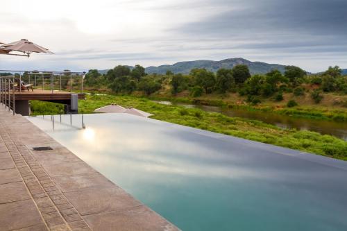 a swimming pool with a view of a river at Royal Mukumbura Malelane in Malelane