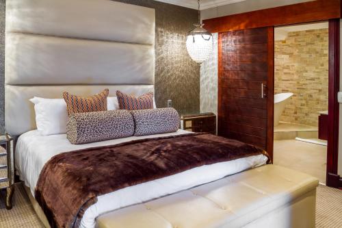 a bedroom with a large bed and a tub at Royal Mukumbura Malelane in Malelane