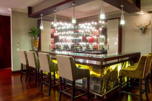 a bar in a restaurant with chairs around it at Royal Mukumbura Malelane in Malelane