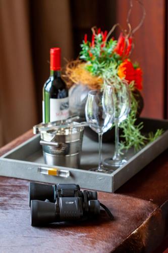 a tray with a bottle of wine and glasses on a table at Royal Mukumbura Malelane in Malelane