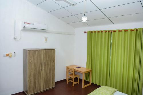 a room with a green curtain and a table at Villa for leisure and work at Kalutara suburbs in Bandaragama