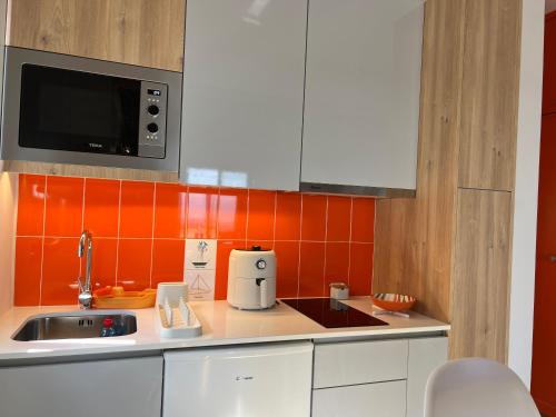 a kitchen with a sink and a microwave at Caniçal houses - Madeira in Caniçal
