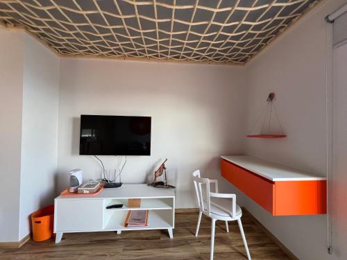a room with a white desk and a tv on a wall at Caniçal houses - Madeira in Caniçal