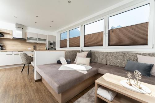 a living room with a couch and some windows at Appartement Schöpf in Längenfeld