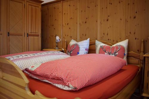 a bedroom with a bed with a red and white comforter at Almsternchen 1 in Oberstdorf