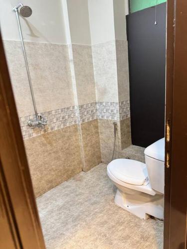 a bathroom with a toilet and a shower at Charming 1BR with Stunning Eiffel Tower View in Rāmkot