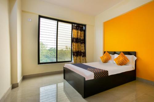 a bedroom with a bed and a large window at SPOT ON Pawan Villa in Gorhe